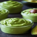 This image beautifully showcases jars filled with fresh avocado cream alongside a halved avocado, highlighting its creamy texture and natural ingredients. This visual can be a fantastic addition to your article, serving as a visual representation of the topic "How Good is Avocado Cream?" and making the content more engaging for readers.